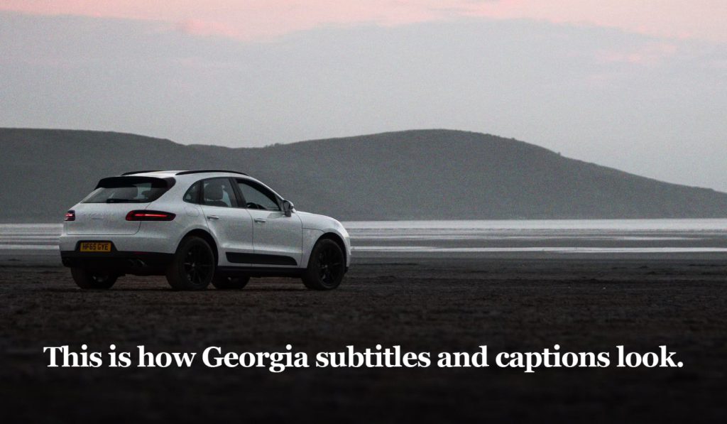 A white Porsche Macan parked on a beach at dusk. Text reads: "This is how Georgia subtitles and captions look."