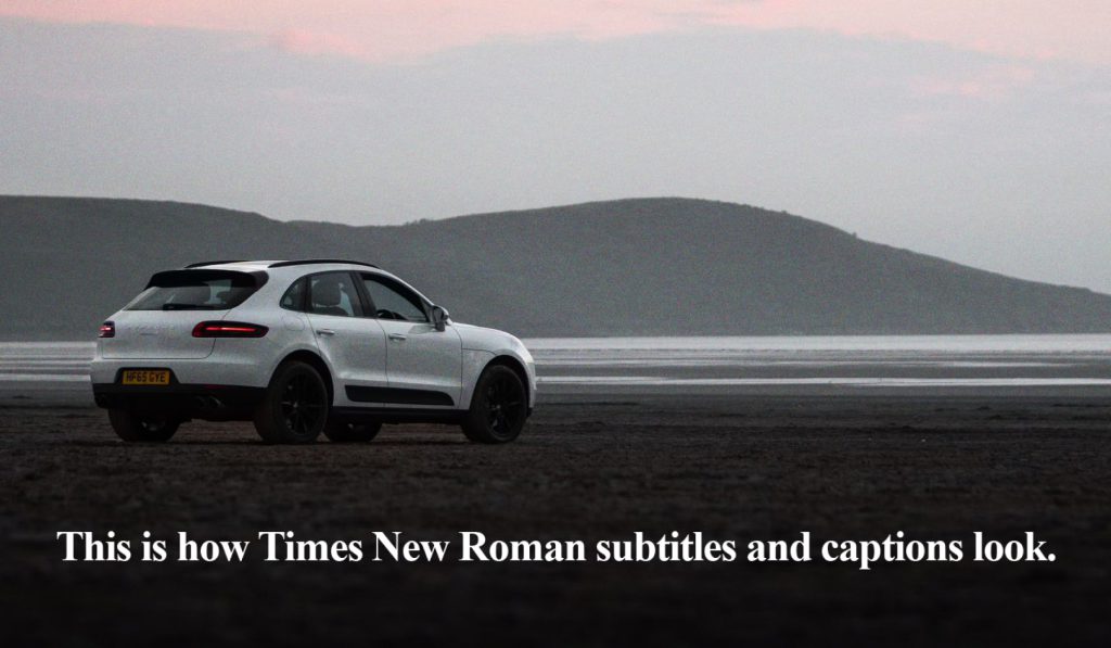 Porsche Macan on a beach at dusk. Text reads: "This is how Times New Roman subtitles and captions look."